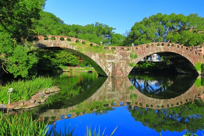 Puente Megane del parque Isahaya: arcos de piedra y verdor